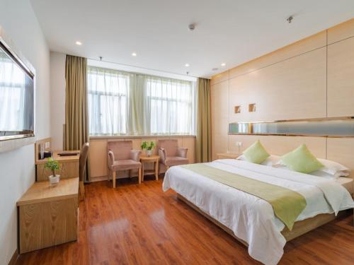a bedroom with a large bed and a table and chairs at Vatica AnHui HeFei Economic Development Zone Hefei University of Technology North Gate Hotel in Ershilipu