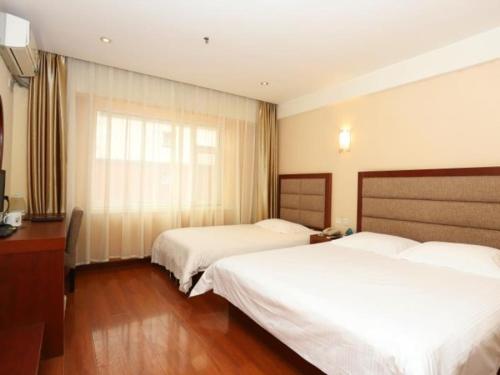a hotel room with two beds and a window at GreenTree Inn Jilin Changchun Haoyue Road Express Hotel in Changchun