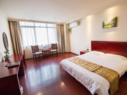 GreenTree Inn AnHui GuangDe ZhongYang LeCheng Business Hotel tesisinde bir odada yatak veya yataklar