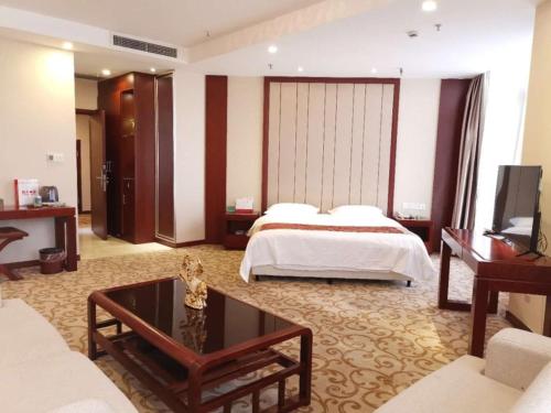 a hotel room with a bed and a coffee table at GreenTree Alliance Xuzhou Gulou District Sanhuan North Road, Jinju Wuliuwan Hotel in Xuzhou
