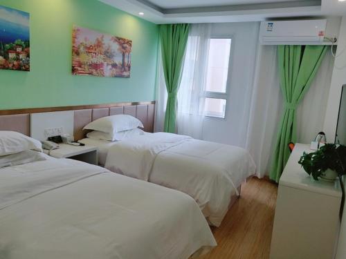 a hotel room with two beds and a window at Shell Shanghai Baoshan District Tieli Road Subway Station Tiefeng Road Hotel in Baoshan