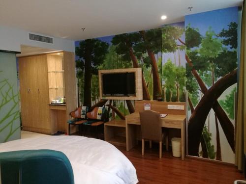 a bedroom with a desk and a computer on a wall at Vatica AnHui HeFei Economic Development Zone Hefei University of Technology North Gate Hotel in Ershilipu
