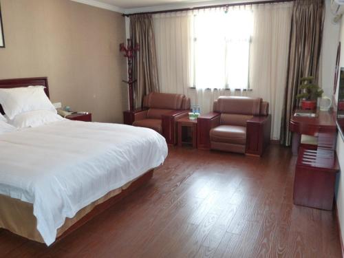 a bedroom with a bed and a chair and a table at GreenTree Inn Anhui Wuhu Fangte North Changjiang Road Business Hotel in Wuhu
