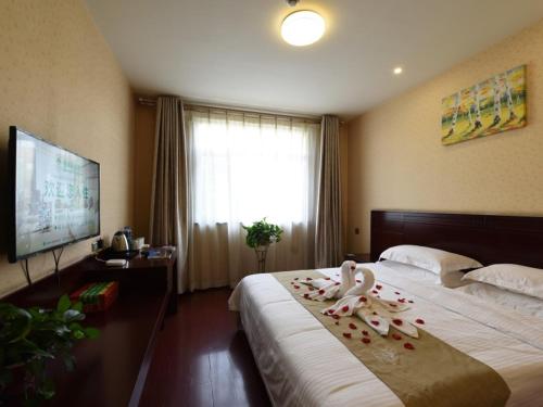 Tempat tidur dalam kamar di GreenTree Inn Shanxi JinZhong JieXiu Railway Station Express Hotel