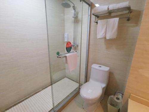 a bathroom with a toilet and a glass shower at GreenTree Inn Jiangsu Suzhou Taicang Liuhe Passenger Station Express Hotel in Taicang