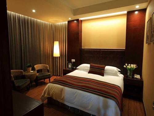 a hotel room with a large bed and a desk at GreenTree Inn Jiangsu Nantong Qidong Middle Heping Road Business Hotel in Qidong