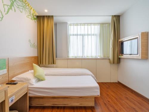 a room with two beds and a desk and a window at Vatica AnHui HeFei Economic Development Zone Hefei University of Technology North Gate Hotel in Ershilipu