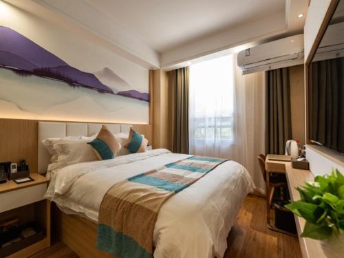 una camera d'albergo con un letto grande e una scrivania di VX Xuzhou Yunlong District Normal University Yunlong Mountain Scenic Spot Hotel a Xuzhou
