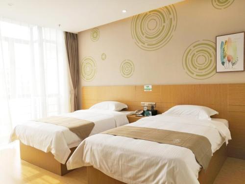 a bedroom with two beds and a window at GreenTree Inn Shanghai Jinshan District Wanda Plaza Longhao Road Express Hotel in Nanhui