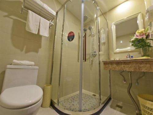 a bathroom with a shower and a toilet and a sink at GreenTree Inn JiangSu Changzhou Dinosaur Park Global Harbor Express Hotel in Changzhou