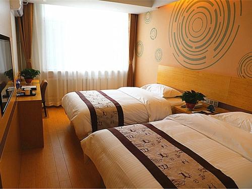 a hotel room with two beds and a television at GreenTree Inn Shenyang Shengjing Hospital Shenyang Liaol Road Business Hotel in Shenyang