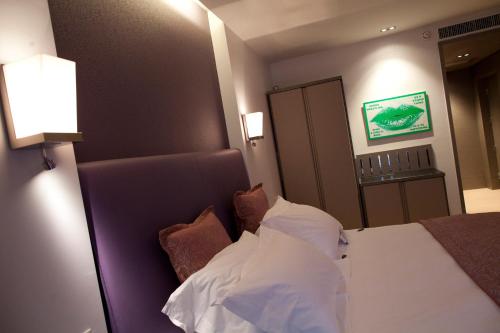 a bedroom with a bed with white sheets and pillows at Crowne Plaza Verona Fiera by IHG in Verona