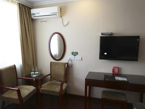 a room with a desk and a tv and a mirror at GreenTree Inn Jiangsu Zhenjiang Yidu Building Materials city Express Hotel in Zhenjiang
