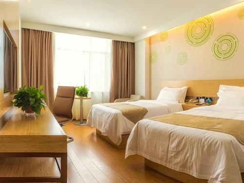 a hotel room with two beds and a window at GreenTree Inn Tangshan Road North District Xishan Road Business Hotel in Tangshan
