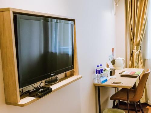 a large flat screen tv hanging on a wall at GreenTree Inn Anhui Xuancheng South Zhuangyuan Road Express Hotel in Xuanzhou