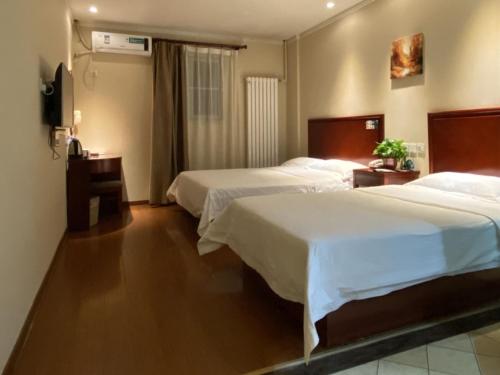 una camera d'albergo con due letti e una televisione di GreenTree Inn Beijing Changping Tiantongyuan East Taipingzhuang Road Express Hotel a Changping