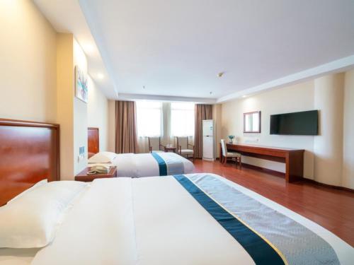 una camera d'albergo con un grande letto e una TV di GreenTree Inn Jiangsu Suzhou Shengze Bus Station Business Hotel a Suzhou
