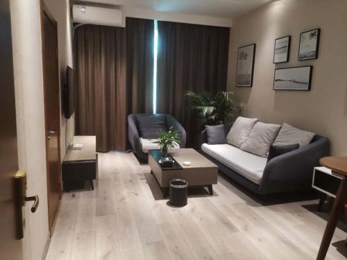 a living room with a couch and a chair at Shell Liaocheng Linqing City Bus Station Hotel in Liaocheng