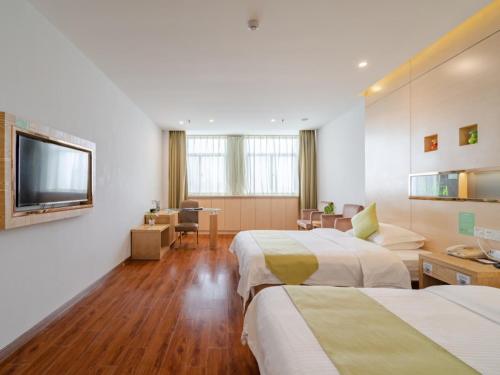 a hotel room with two beds and a flat screen tv at Vatica AnHui HeFei Economic Development Zone Hefei University of Technology North Gate Hotel in Ershilipu