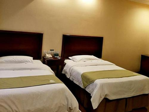 a bedroom with two beds and a telephone at GreenTree Alliance Beijing Daxing District Jiugong Town Jiugong Subway Station Hotel in Hongxing