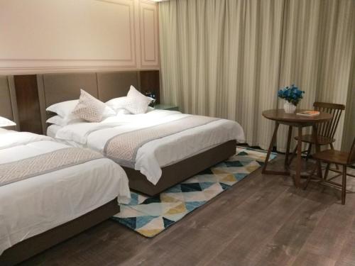 una camera d'albergo con due letti e un tavolo con sedie di GME Huainan Tianjiaan District Chaoyang East Road Hotel a Huainan