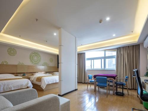 um quarto de hotel com duas camas e uma mesa e cadeiras em GreenTree Inn Changzhou Menghe Town Chengfeng Building Business Hotel em Changzhou