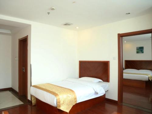 Ένα ή περισσότερα κρεβάτια σε δωμάτιο στο GreenTree Inn Jiangsu Taizhou Taidong Railway Station Business Hotel