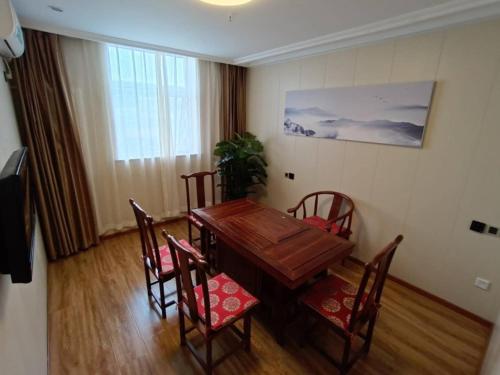 a dining room with a wooden table and chairs at GreenTree Inn Beijing Fangshan Liangxiang Suzhuang Express Hotel in Fangshan