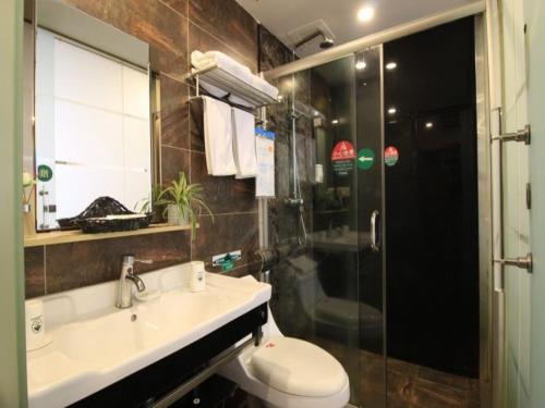 a bathroom with a toilet and a sink and a shower at GreenTree Inn WenZhou LuCheng XiaoNanMen Express Hotel in Wenzhou
