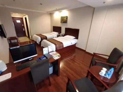 a hotel room with two beds and a desk with a computer at GreenTree Inn Shanghai Jiading Dazhong International Auto City Business Hotel in Jiading