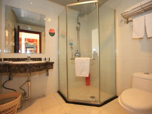 uma casa de banho com um chuveiro, um WC e um lavatório. em GreenTree Inn Hebei Zhangjiakou Xuanhua Bus Station Shell Hotel em Zhangjiakou