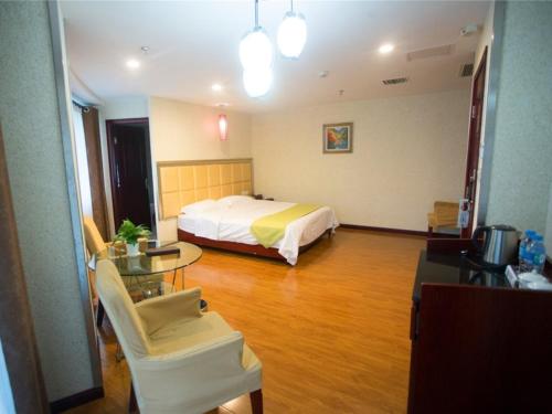 a hotel room with a bed and a table and chair at GreenTree Alliance Nanping Yanping District Xinjian Road Hotel in Nanping