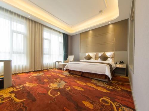 a hotel room with a bed and a large rug at GreenTree Eastern Yibin Yijian Road New City Plaza Hotel in Baixi