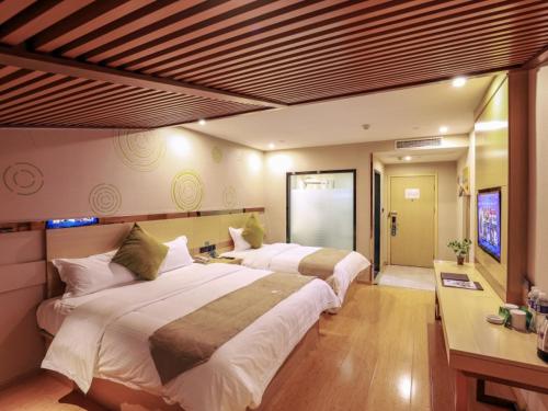 um quarto com 2 camas grandes e uma televisão em GreenTree Inn Wuxi Yixing High-speed Railway Station Dingshu Town Tongshu Road Express Hotel em Wuxi