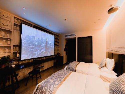 a bedroom with two beds and a large screen television at GME Lu'an Yeji District Administrative Center Hotel in Lu'an