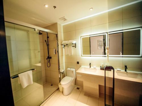 ein Badezimmer mit Toilette, Waschbecken und Dusche in der Unterkunft GreenTree Inn Taizhou Xinghua City Zhouzhuang Town Business Hotel in Taizhou