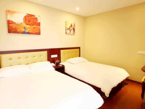 a bedroom with two beds with white sheets at GreenTree Inn Shanghai Outlets National Convention Centre XuLe Road Shell Hotel in Qingpu