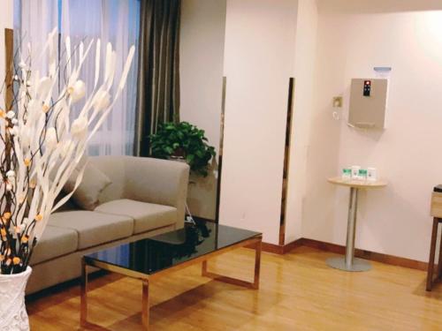 a living room with a couch and a glass table at GreenTree Inn Suzhou Dangshan Yanxi Road Hotel in Dangshan
