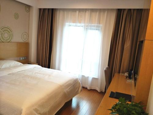a bedroom with a bed and a large window at GreenTree Inn Tianjin Dongli Development Zone Huamingzhen Airport Express Hotel in Tianjin