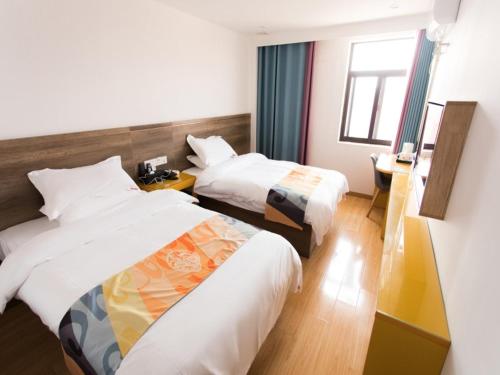 pokój hotelowy z 2 łóżkami i oknem w obiekcie Shell Liu'an Wanxi Avenue International Motor City Hotel w mieście Lu'an