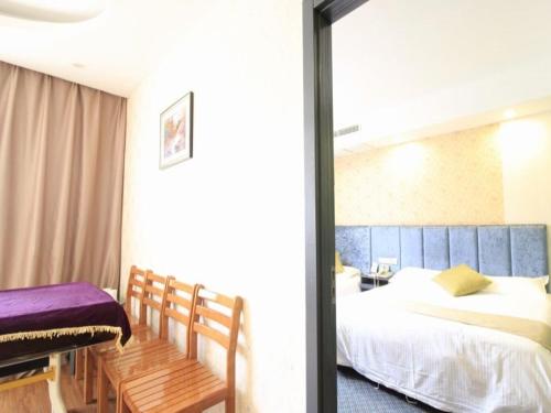 a bedroom with a bed and a table and a window at GreenTree Inn WenZhou LuCheng XiaoNanMen Express Hotel in Wenzhou