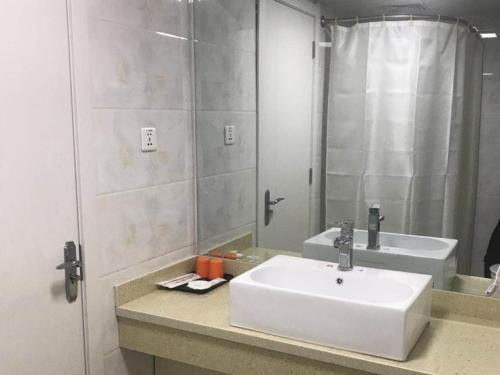 a bathroom with a white sink and a mirror at Shell Shangxi Xinzhou Dai County 108 State Road Hotel in Dai