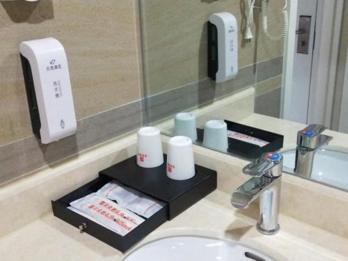 a bathroom counter with a sink and a mirror at Shell Chengde Xinglong County Banbishan Town Hotel in Xiabancheng