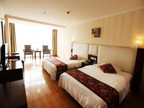 Habitación de hotel con 2 camas, mesa y sillas en GreenTree Inn JiangSu LianYunGang Bus Station East JieFang Road Business Hotel, en Lianyungang