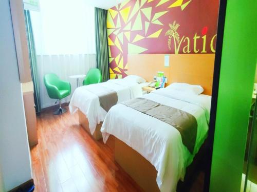 a hotel room with two beds and a green wall at Vatica Hefei Yaohai District Linquan Road Anhui Big Market Hotel in Hefei