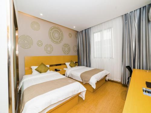 a hotel room with two beds and a window at GreenTree Inn Suzhou Zhangjiagang City Jingang Town Express Hotel in Zhangjiagang