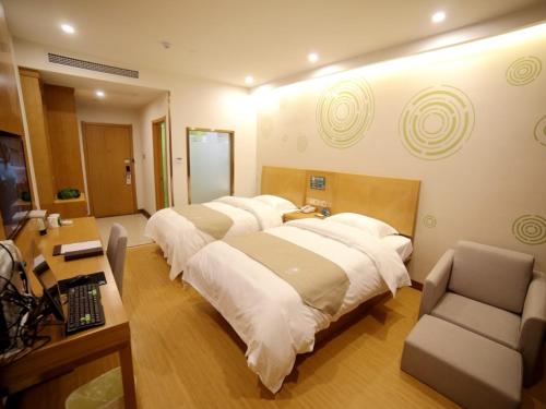 a hotel room with a large bed and a desk at GreenTree Inn Fuyang Development Zone Weisan Road Express Hotel in Fuyang