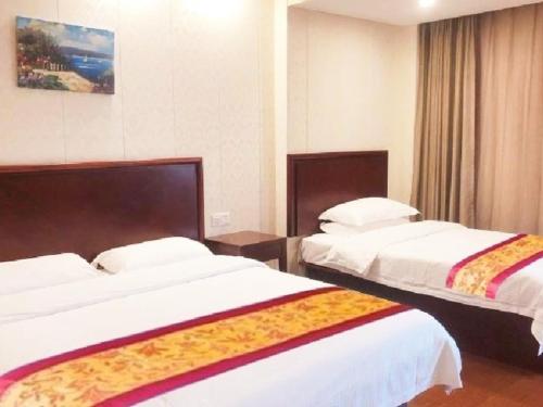 a hotel room with two beds with white sheets at GreenTree Inn Shanghai MinHang District PuJiang Town JiangYue Road Metro Station Hotel in Shanghai