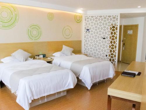 a hotel room with two beds in a room at GreenTree Inn HuaiAn Huaiyin Area The Yangtze River East Road Express Hotel in Huai'an