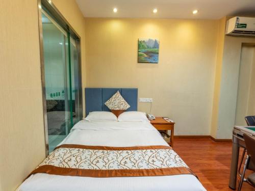 a bedroom with a large bed in a room at Greentree Inn Jiangsu Suzhou Wujiang yongkang Pedestrian Road Express Hotel in Suzhou